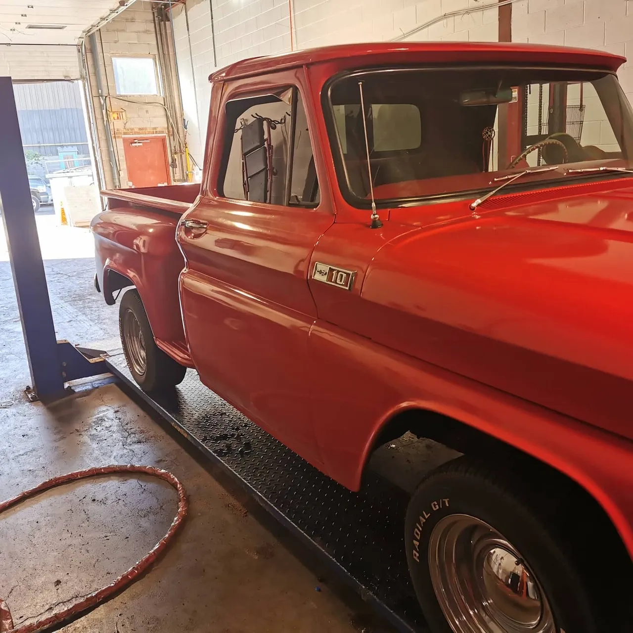 red Chevy C10 classic truck on hoist for rust check at Ultimate Detail Bowmanville